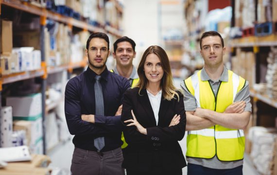 Portrait of warehouse manager and workers in warehouse